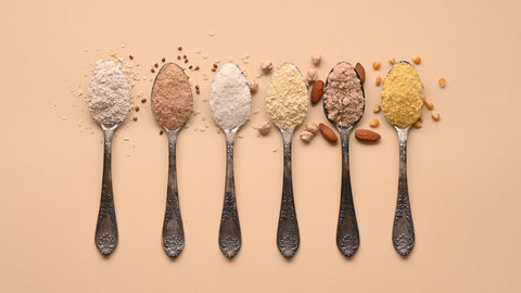 A neutral background with 6 spoons laid out. Each spoon contains a powdered ingredient in different colors. Gluten-Free Fiber Supplement