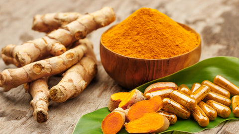 Root, powder, slices and supplement forms of turmeric shown on a wooden table. Turmeric for Bodybuilding: 5 Benefits You Need to Know About