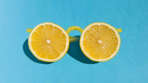 Glasses made from fresh lemon slices and plastic lemonade straws on a bright blue background. Vitamin C for Eyes